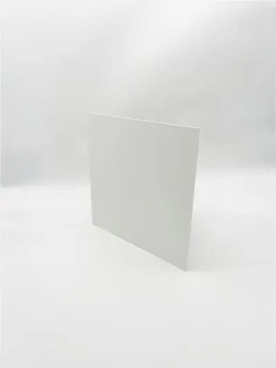 A plain white rectangular board resembling dock door signs stands upright on a white surface.