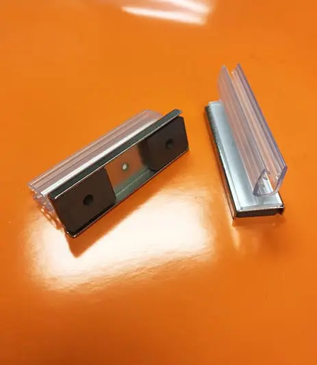 Two small plastic label holders rest on an orange surface.